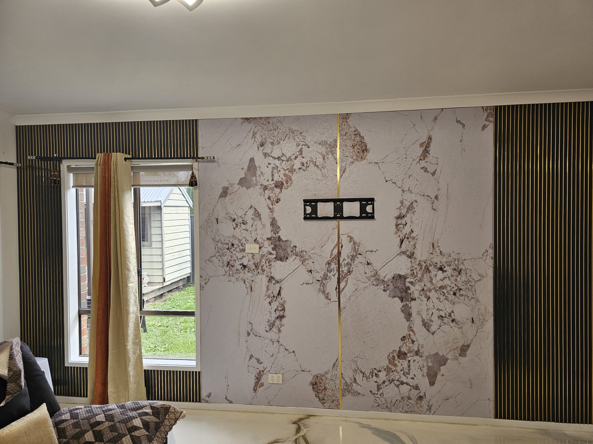 Panel wall installation with marble panels and gold strips